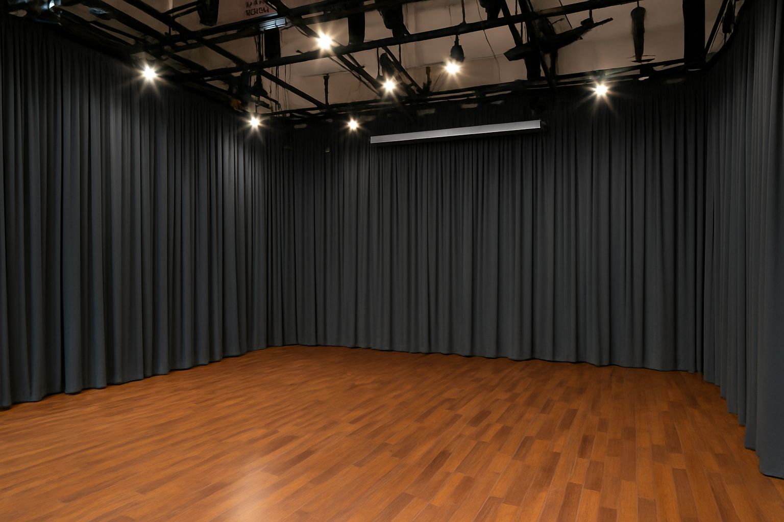Dark full-height curtains surrounding a studio with a timber floor